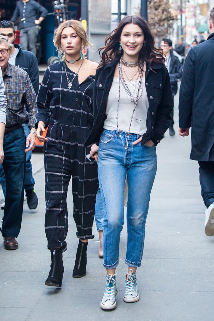 Wearing Converse sneakers, high-waisted denim, and layered jewels.