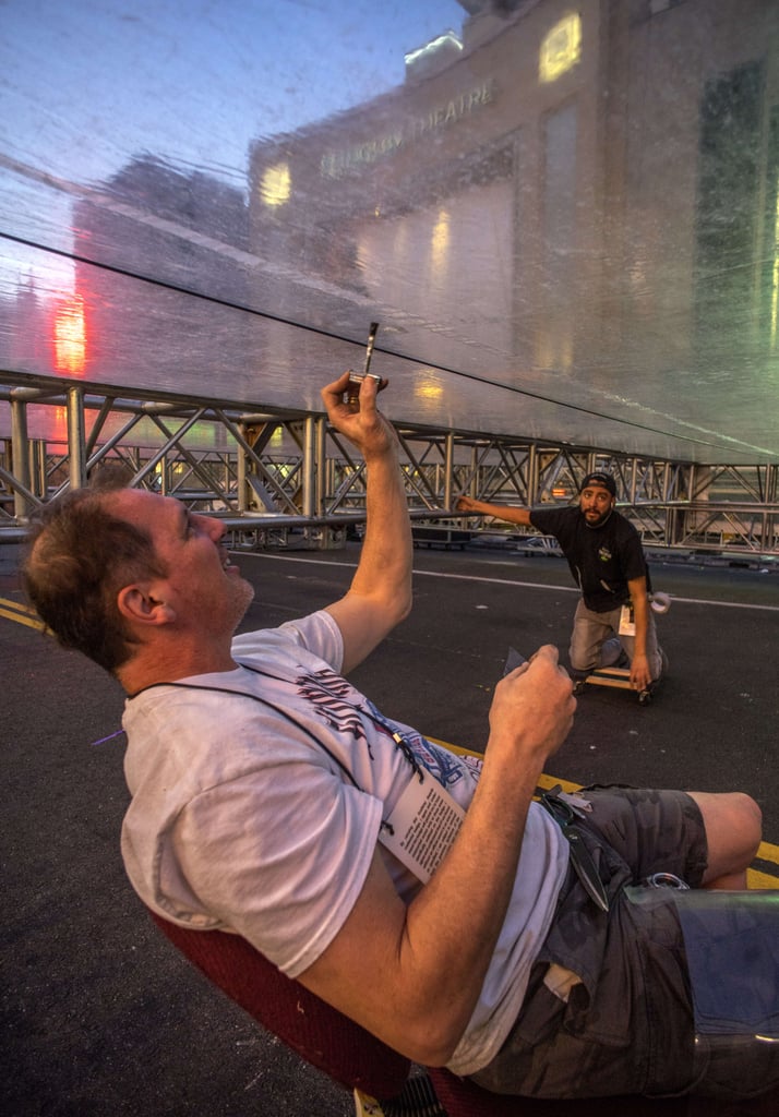 Workers patched holes in the plastic roof over the red carpet.