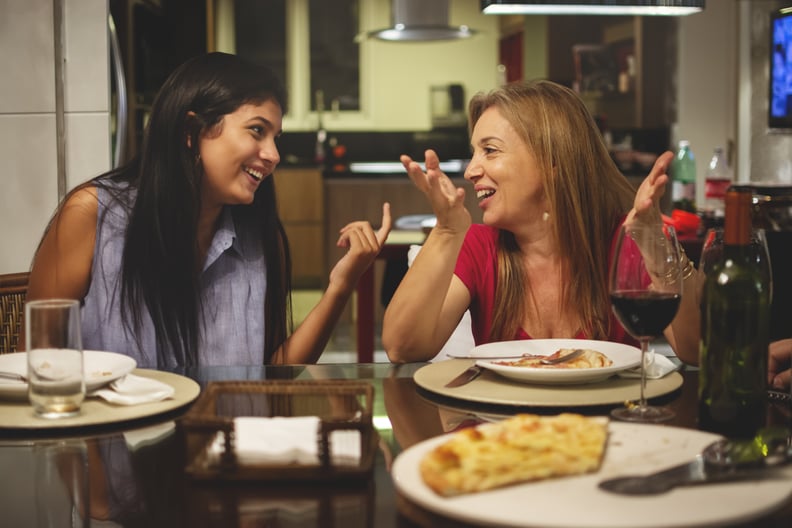 Mother and daughter eating pizza at dining table