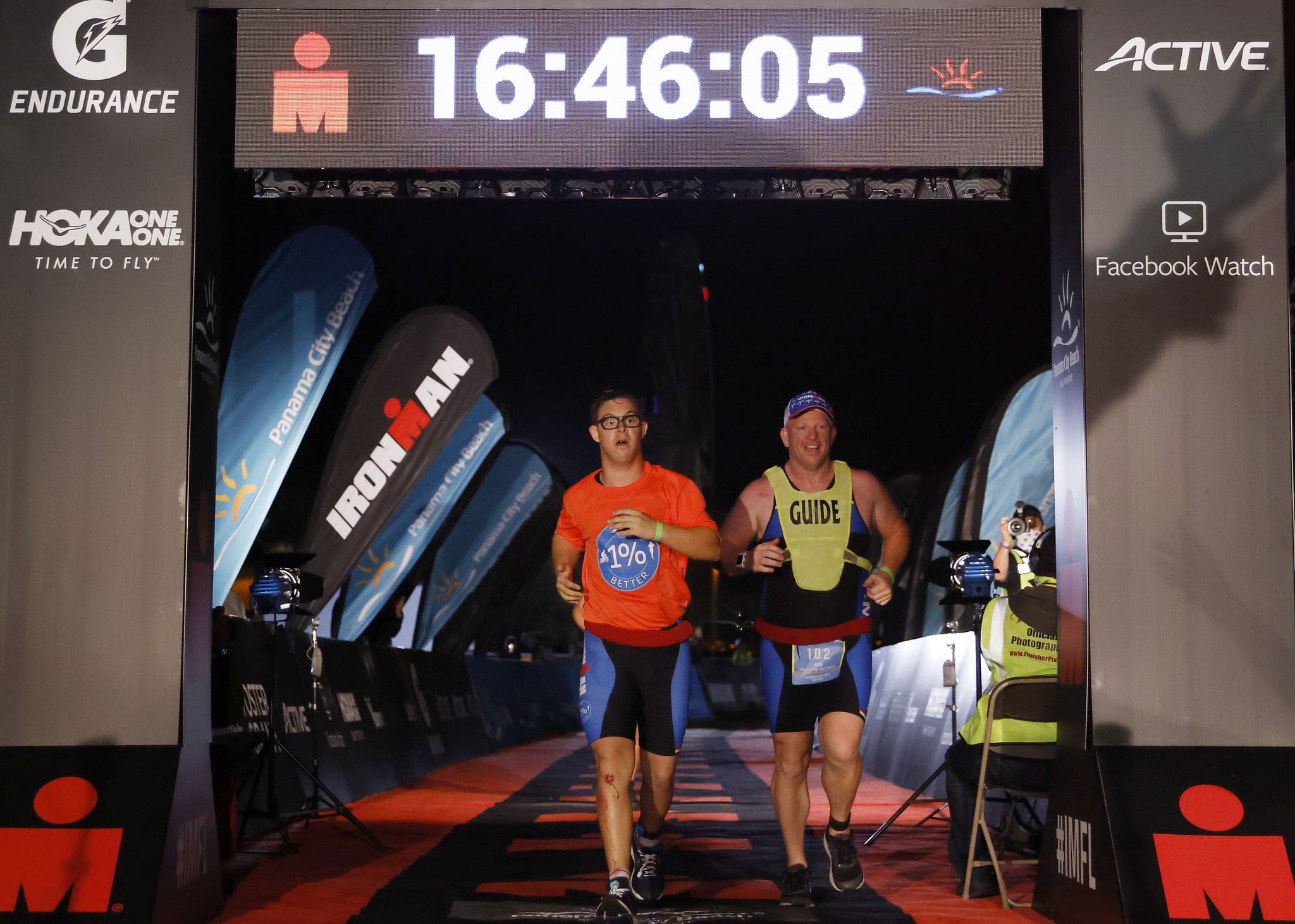 PANAMA CITY BEACH, FLORIDA - NOVEMBER 07: Chris Nikic and his guide Dan Grieb cross the finish line of IRONMAN Florida on November 07, 2020 in Panama City Beach, Florida. Chris Nikic became the first Ironman finisher with Down syndrome. (Photo by Michael Reaves/Getty Images for IRONMAN)