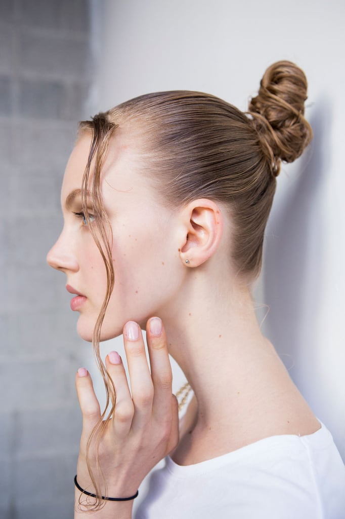 As a rule of thumb, when hair is wet, it's easier to wrap it up into itself. For a visual, imagine all those times when you've wrapped your hair into a bun after getting out of the shower or a pool without using a hair tie (re: the "twist and tuck" method). You'll have a sleek updo, like this one from the Thakoon runway show, that's strong enough to hold itself up without having to search for a hair band.