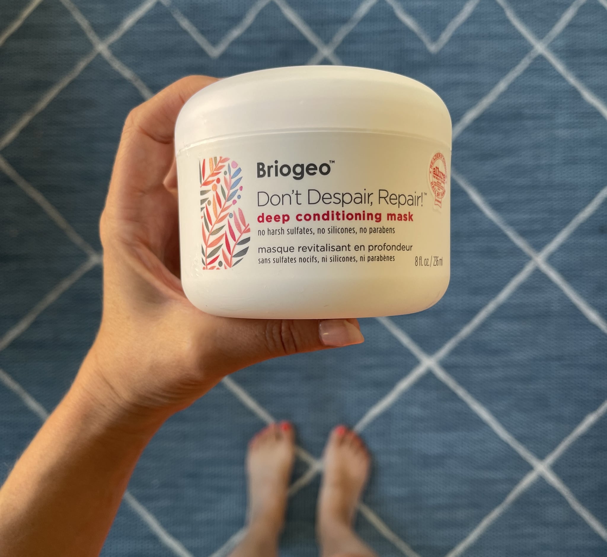 woman holding a tub of Don't Despair, Repair! Deep Cnditioning Hair Mask