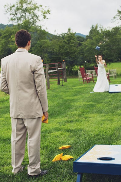 Lawn games, such as cornhole toss, serve as an easy way for guests to break the ice during the cocktail hour at an outdoor wedding.