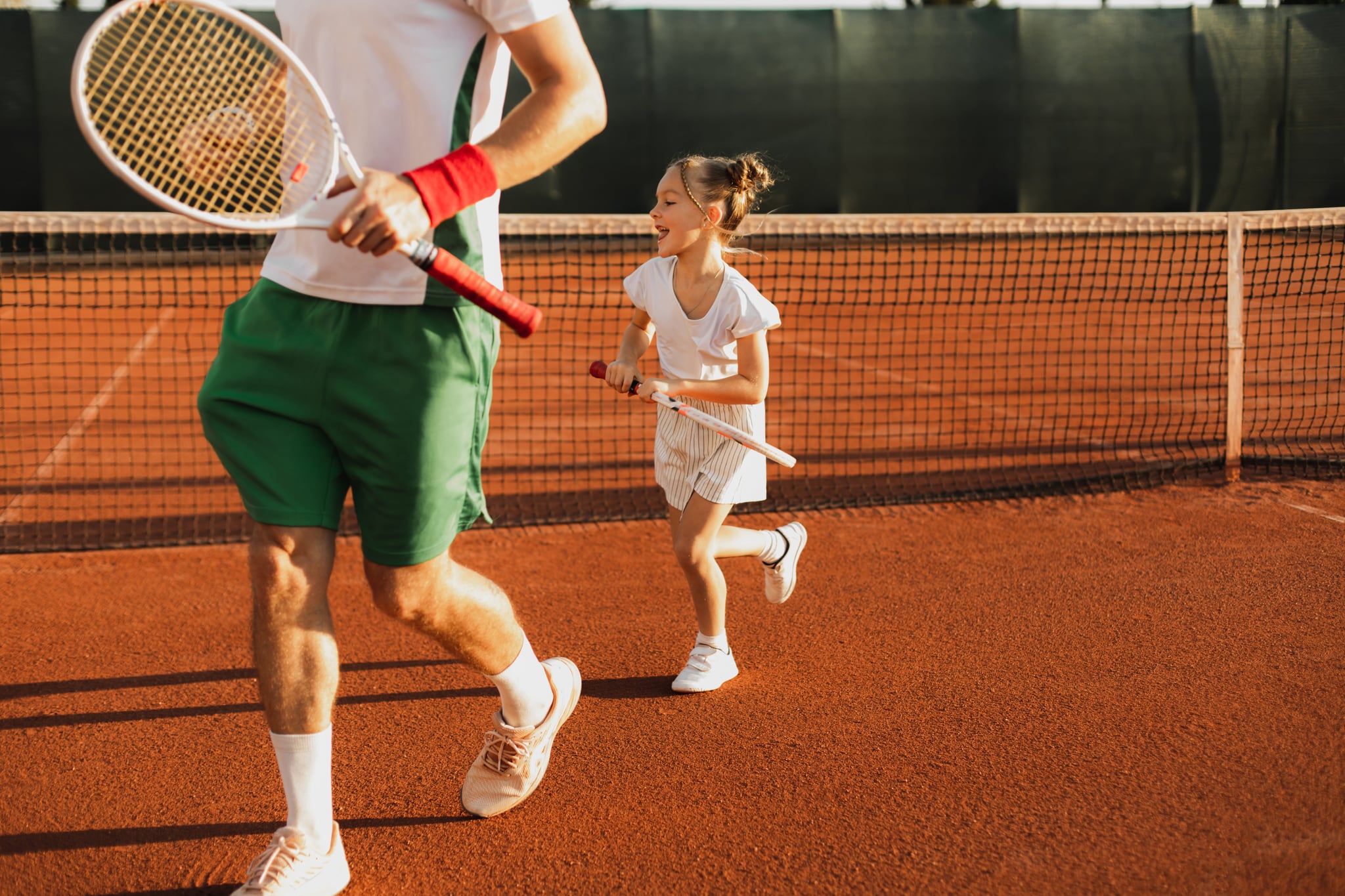 father and daughter playing tennis