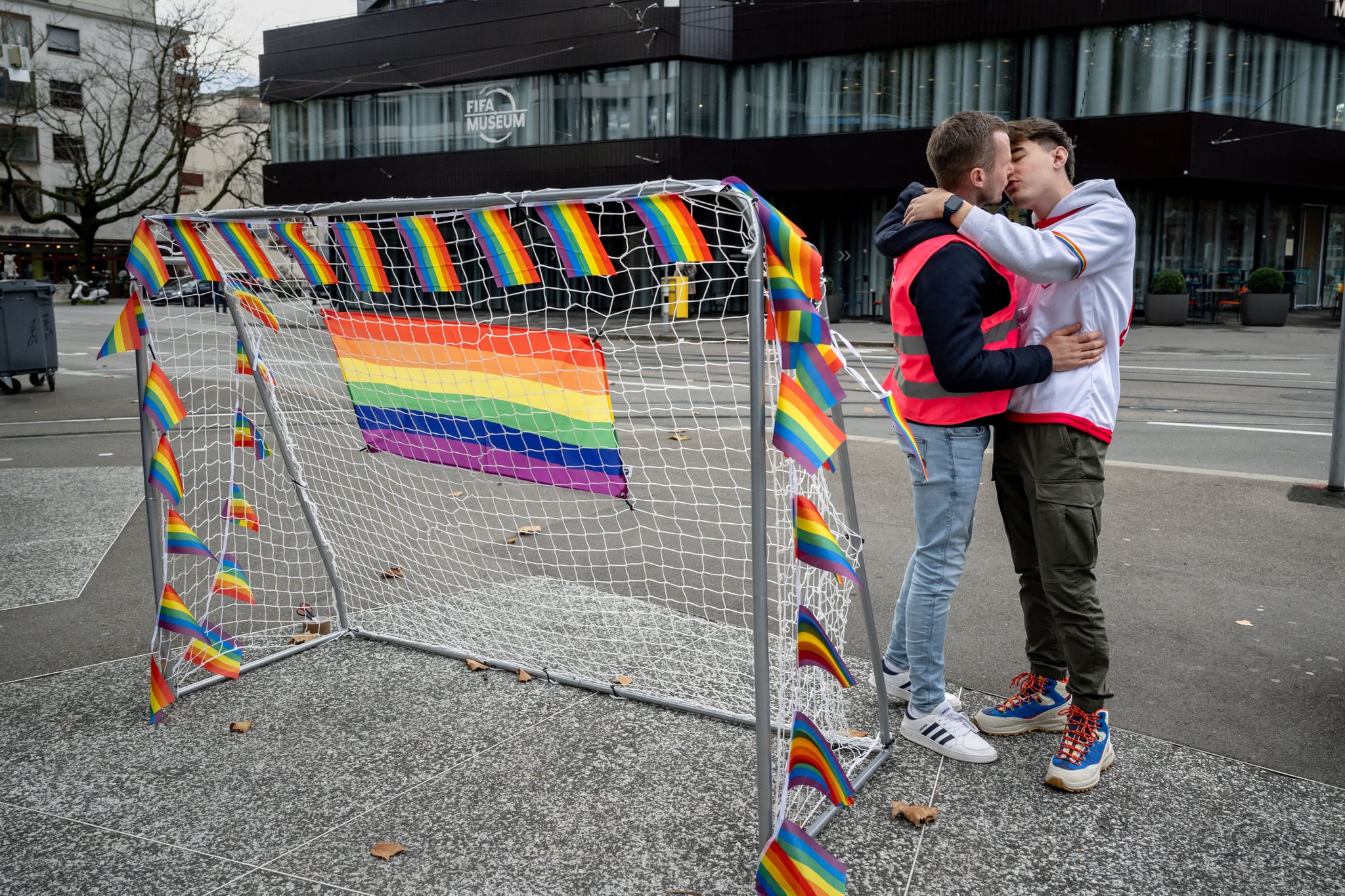 Two men kisses next to a goal during a symbolic action by LGBT+ associations in front of the FIFA museum in Zurich on November 8, 2022, to call FIFA to defend the rights of the LGBT+ community ahead of the Qatar 2022 FIFA World Cup football tournament that will start on November 20. (Photo by Fabrice COFFRINI / AFP) (Photo by FABRICE COFFRINI/AFP via Getty Images)