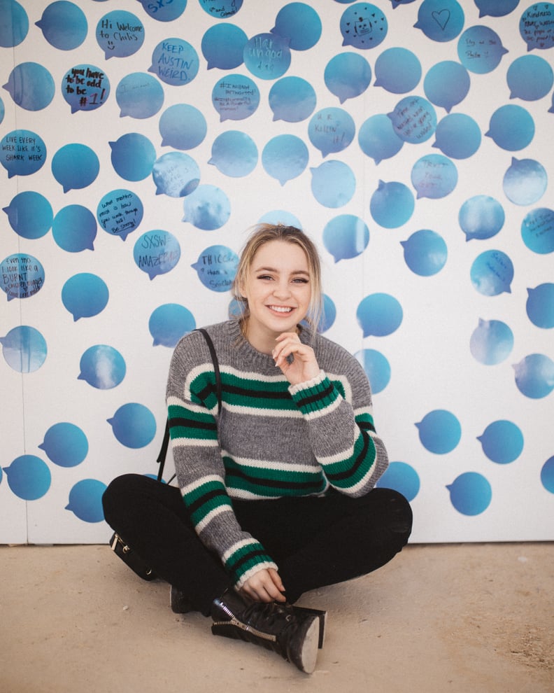 Social Media influencer Alexa Losey sat for a photo in front of the wall.
