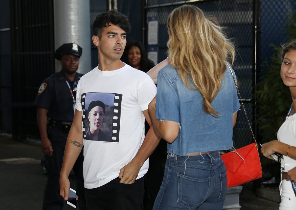 Gigi finished her Canadian tuxedo with a cherry red envelope bag by Roland Mouret.
