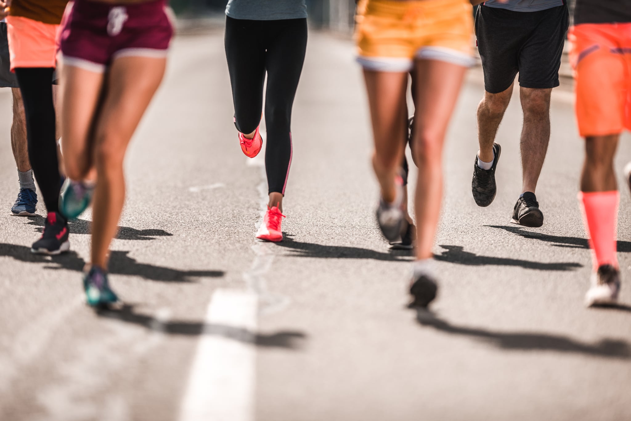 Unrecognizable athletic people running a marathon on the road.
