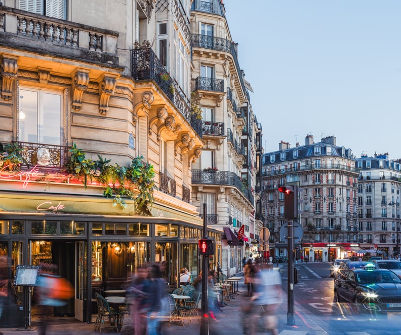 A Parisian street is shown at dusk.