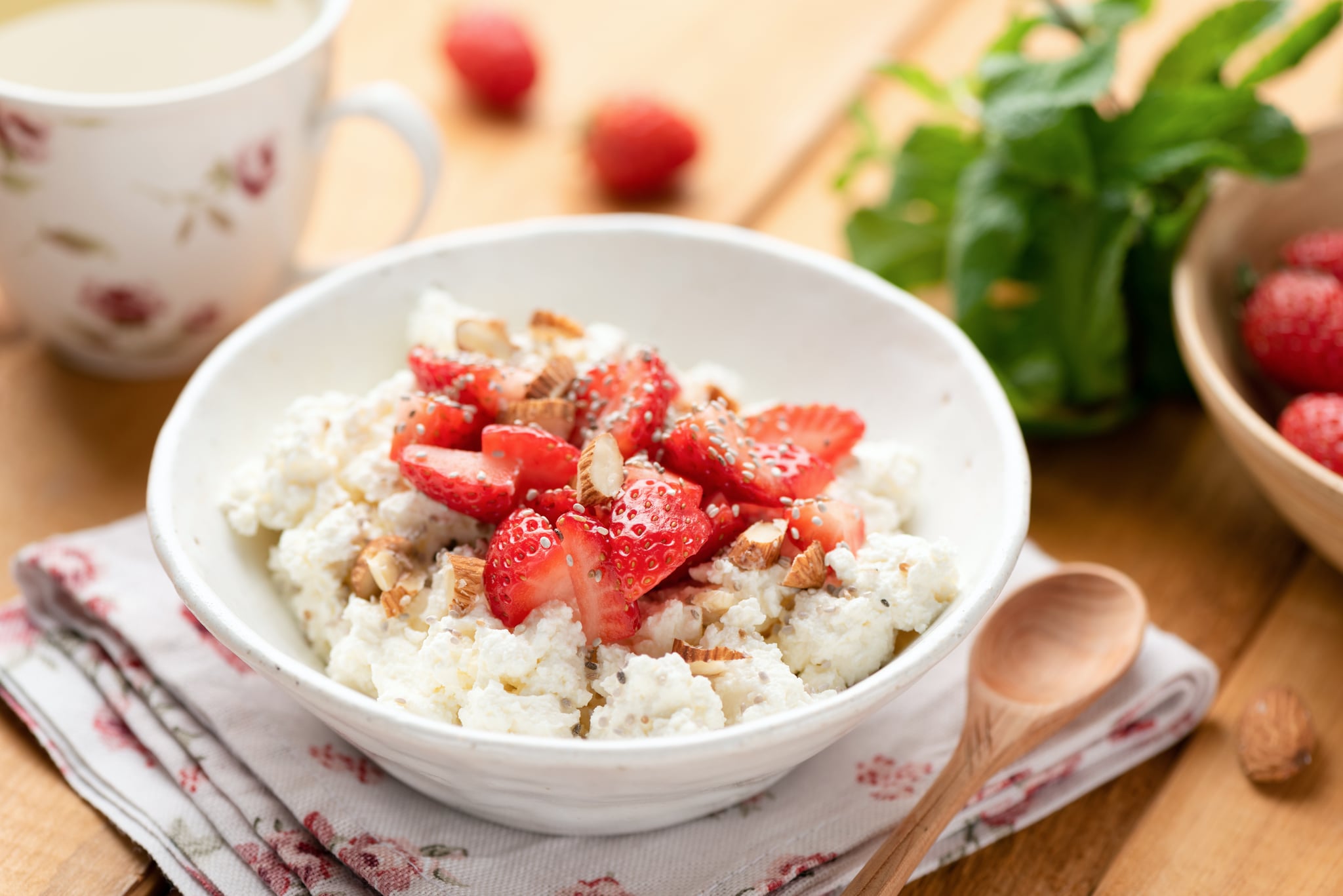奶酪和草莓在碗芡欧鼠尾草种子木桌上。健康的早餐,健康饮食的概念