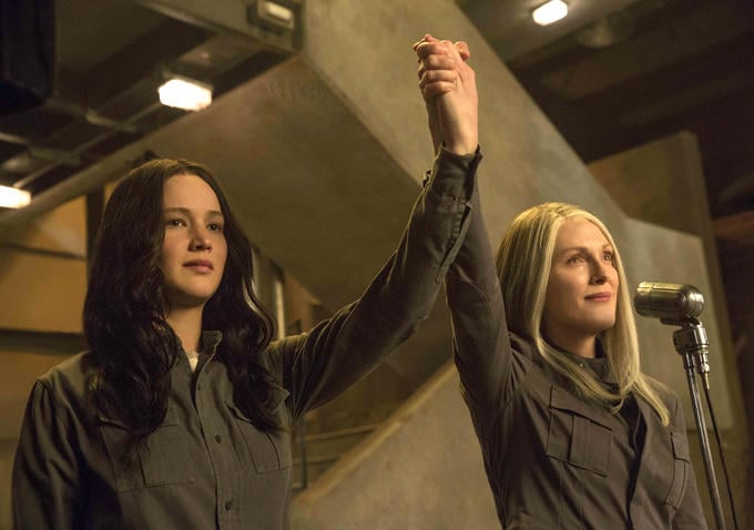 Katniss and President Coin raise their hands in union. And they almost look like they're smiling.