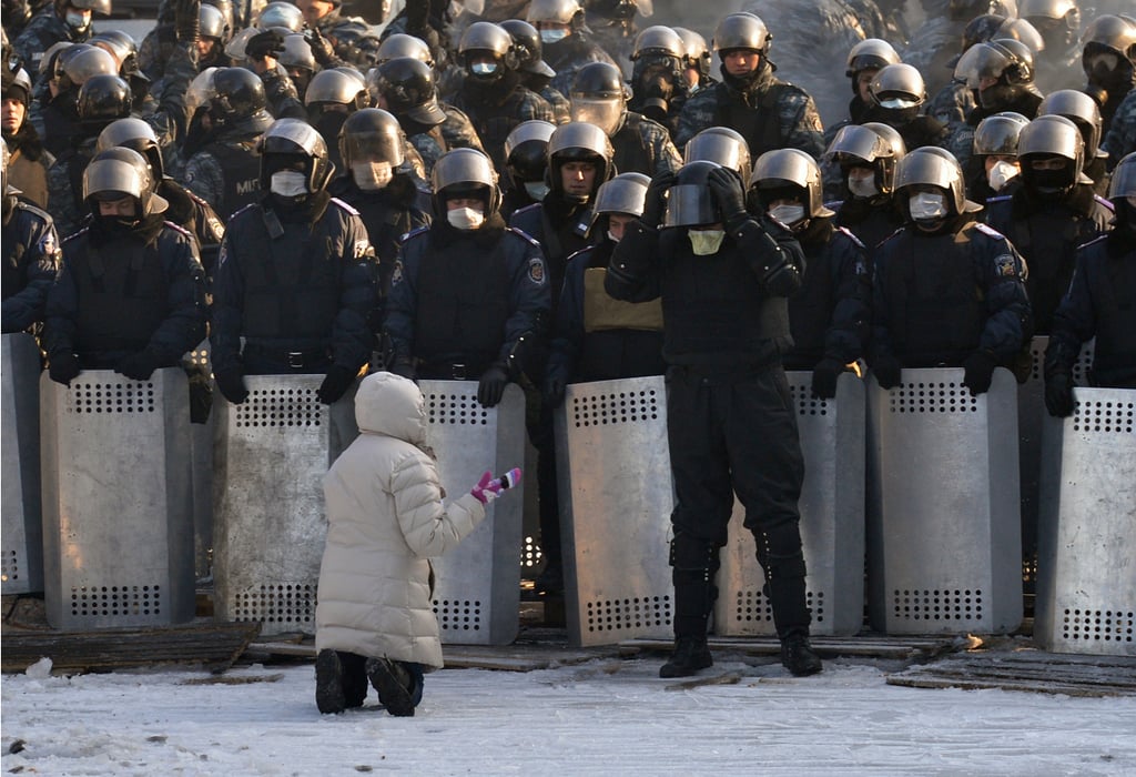A woman spoke out as she knelt in front of police in Kiev.