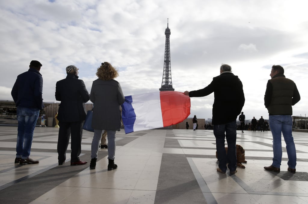 People held a French flag in front of the Eiffel Tower during France's minute of silence.