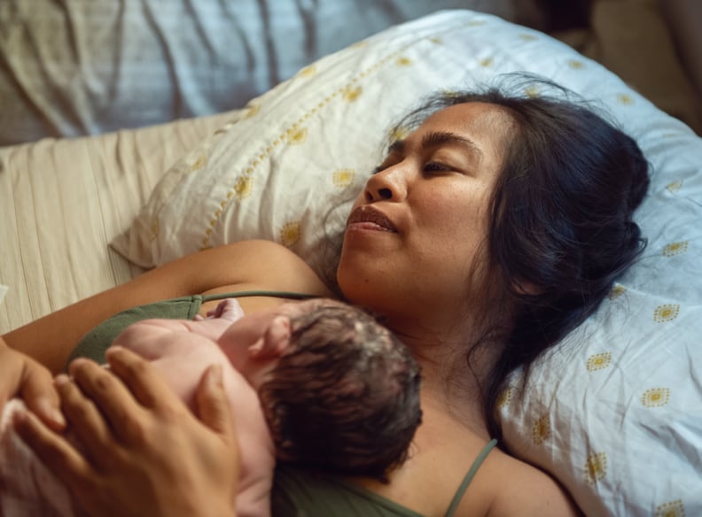 A woman who just experienced a home birth holds her just born baby.