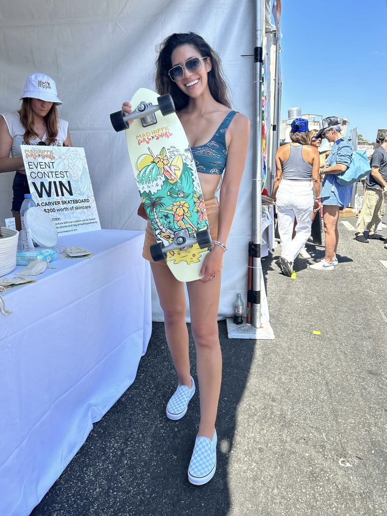 the author holding a Mad Hippie Beauty x GRLSWIRL skateboard