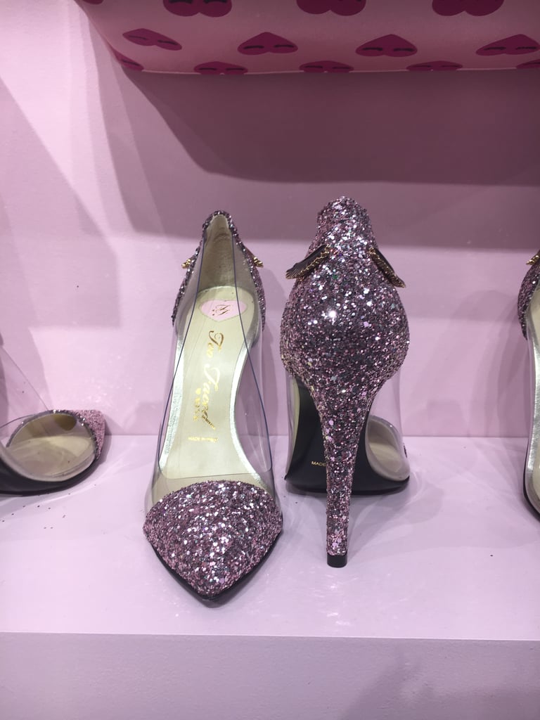While the pop-up's piece de resistance — the Better Than Sex Stilettos ($225) — speak for themselves, Jerrod kindly gave us the backstory on how the sky-high heels came to be. 
"I was working with Erika Jayne, and we came up with this Cinderella-esque story," Jerrod recalled. "I played a fairy godfather janitor, and we needed a shoe." Over the course of a year, the duo worked with the Italian company Mink Shoes to produce the vegan glitter heels.
While the toe and heels of the stiletto are covered in millennial pink glitter, the sides are see-through — that's a nod to the "glass slipper" inspiration. To finish things off, two lashes adorn the back of the shoe. ("So you can wink as you're leaving," Jerrod explains.)
Jerrod stressed that the heels are available only in "super limited quantities," but if you're fast enough, you can actually purchase these bad boys from the comfort of your couch. Starting on Oct. 18, you can cop the Better Than Sex Stilettos ($225) on the Too Faced website.