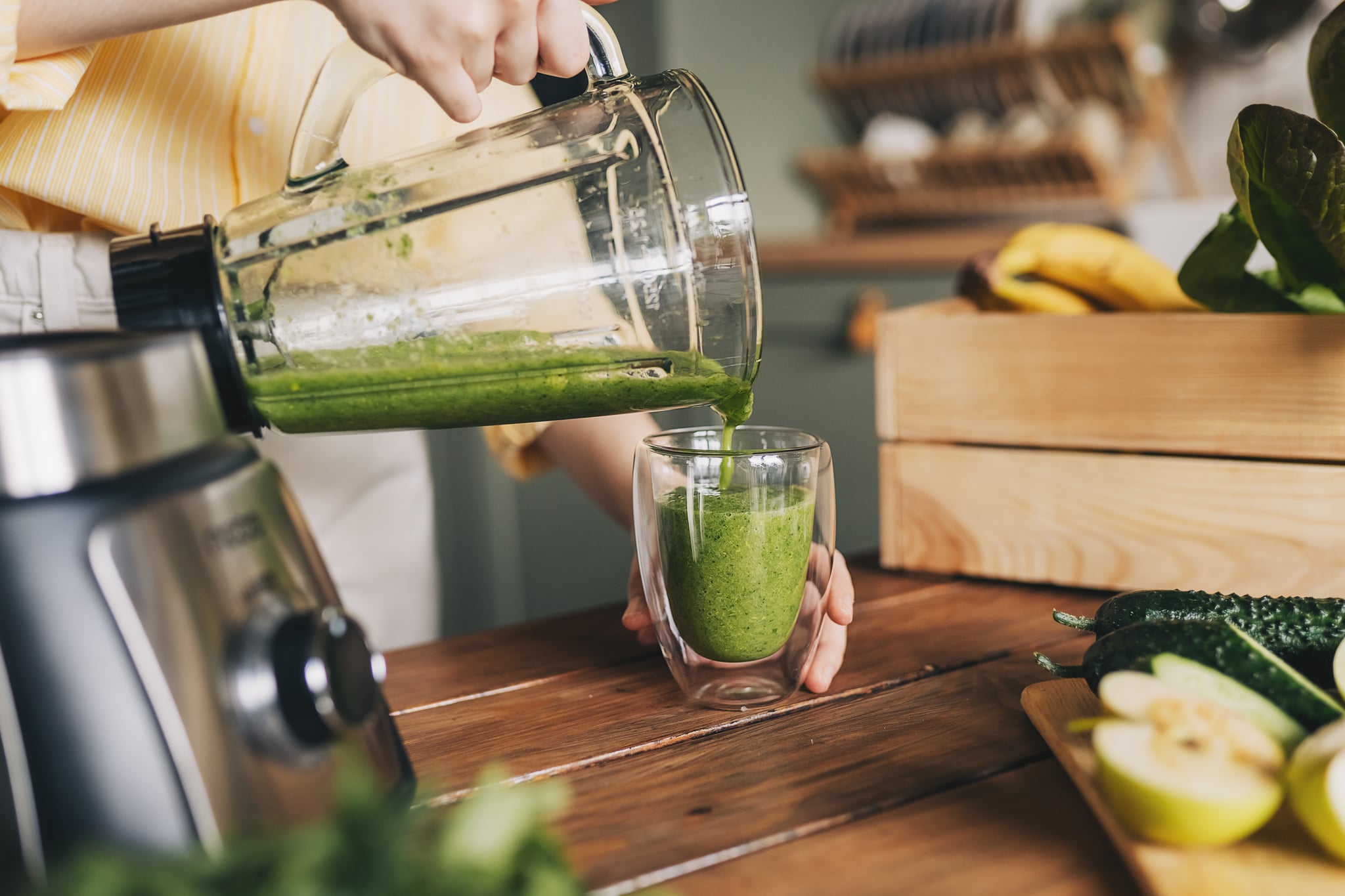 person pouring green smoothie from blender into glass: are smoothies healthy?