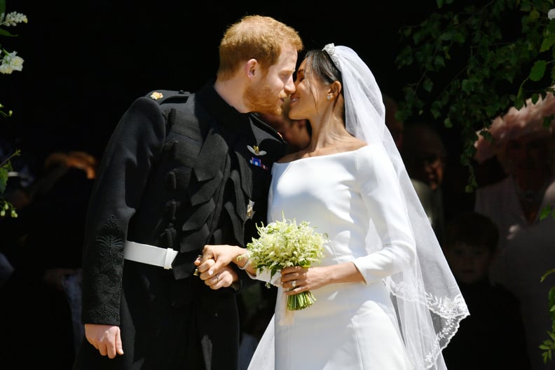 Britain's Prince Harry, Duke of Sussex kisses his wife Meghan, Duchess of Sussex as they leave from the West Door of St George's Chapel, Windsor Castle, in Windsor, on May 19, 2018 after their wedding ceremony. (Photo by Ben Birchall / POOL / AFP)        