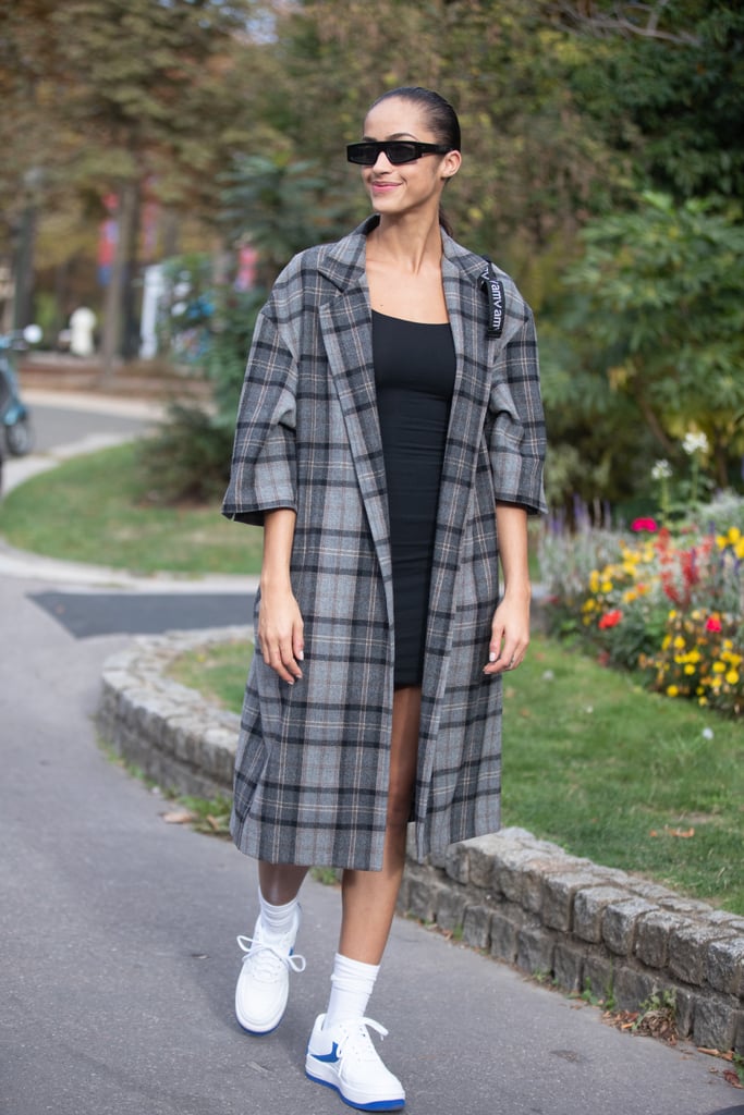 White Nikes and white socks have never looked cooler than they do paired with a little black dress and a fresh trench.