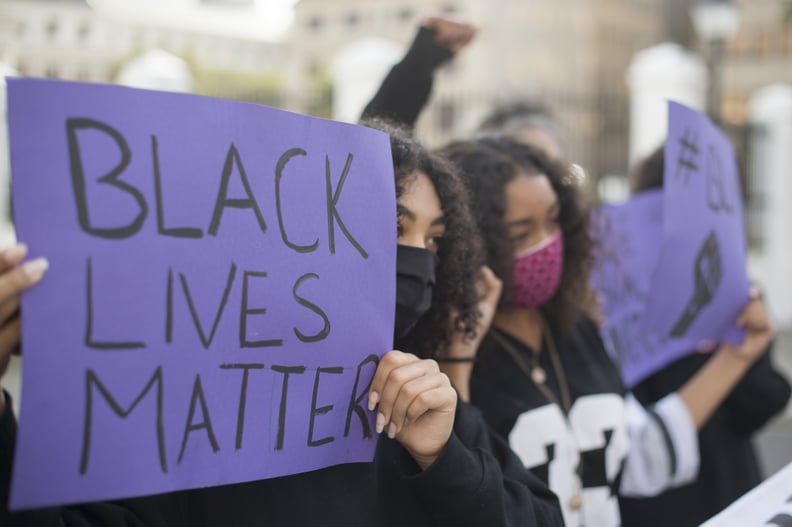抗议者高举标语牌在抗议警察暴力,在盖茨在开普敦南非议会,2020年6月3日。——这个抗议声援黑人生命物质运动在美利坚合众国(美国),一个