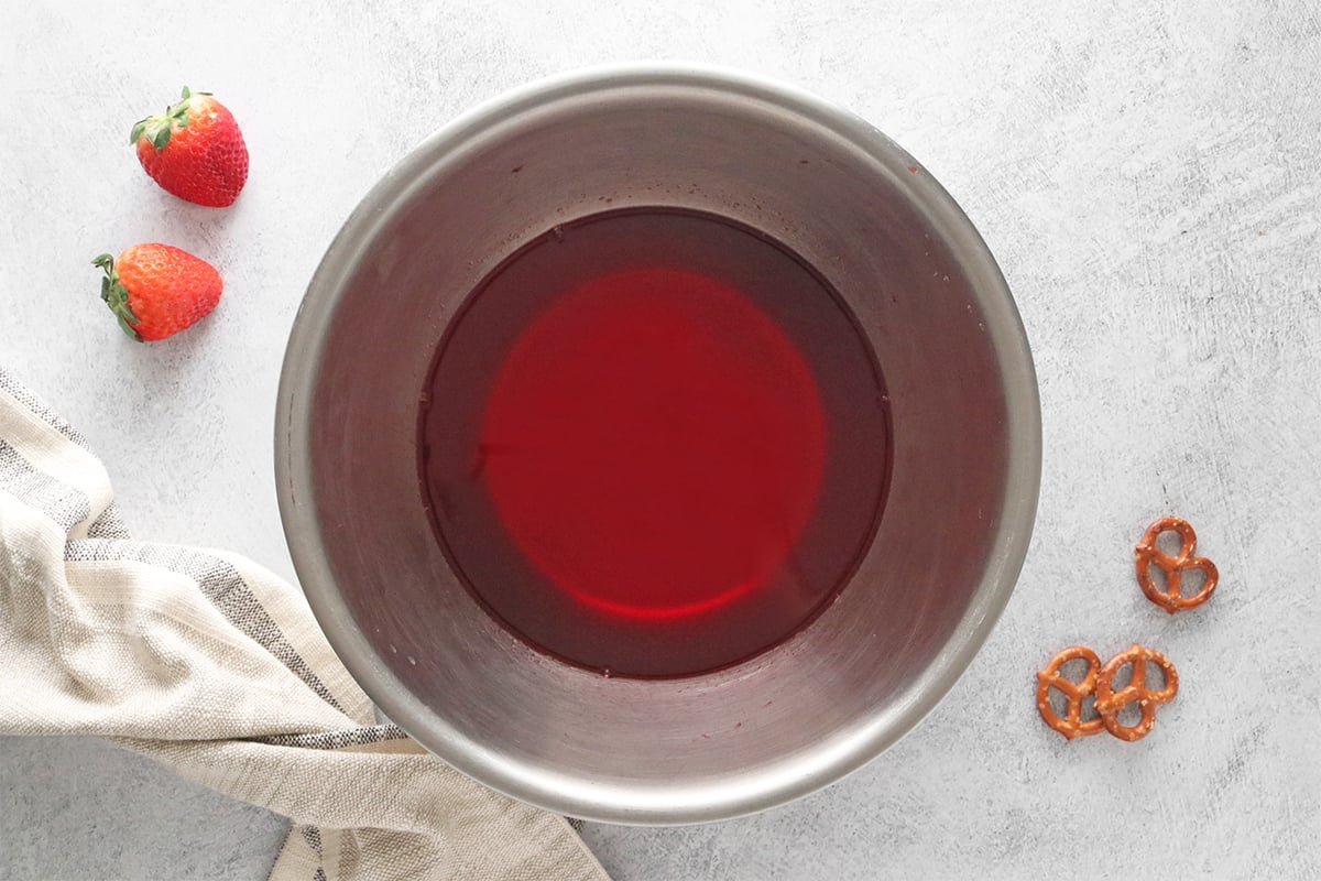 Strawberry gelatin and hot water in a bowl