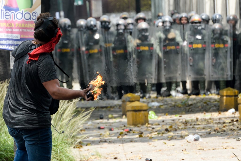 A protestor gets ready against police.