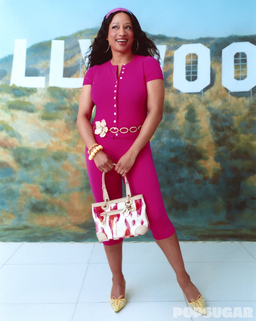 Helsa Beckette Knit Cardi ($249). Helsa Beckette Knit Capri ($229). Valentino 2002 Tortoise Shell Flower Belt ($115 to rent). Hot Pink Headband ($8). Jimmy Choo Scarlett 50 Pumps, available in black ($1,150). Laura Lombardi Suona Necklace ($268).
Capri pants were a major sensation in 2006, and 20 years later, they're dominating the fashion landscape once again. Coleman shows off the enduring power of the trend in a pink Helsa two-piece set paired with a vintage Christian Dior tote sourced from eBay, a Valentino flower belt, Jimmy Choo pumps, and Laura Lombardi jewelry.
Get The Look: Baby Phat Hot Pink Tee ($14, originally $16). Sumwon Low-Rise Knitted Capri Pants ($24). Farm Rio Vintage Gold Flower Metal Chain Belt ($178). Nine West Rizze Women's Pointy Toe Slingback Pumps ($76, originally $90).