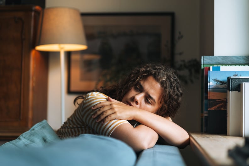 Tired woman sitting on the couch, dangers of sleep detoxing.