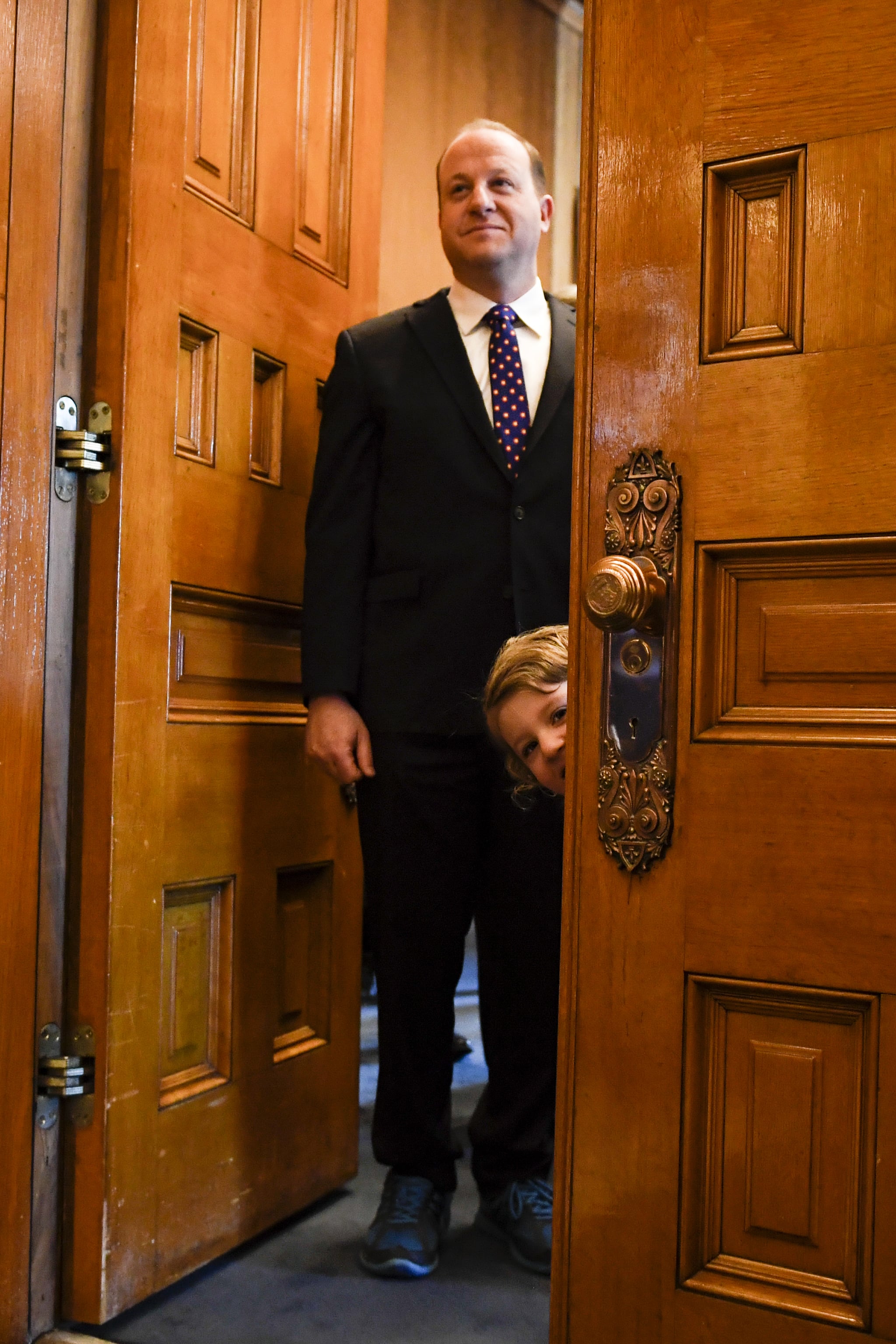 DENVER, CO - JANUARY 8: Governor-elect Jared Polis stands in his office as his daughter, Cora, pokes her head out,  before his inauguration at the Colorado State Capitol on Tuesday, January 8, 2019. (Photo by AAron Ontiveroz/The Denver Post via Getty Images)