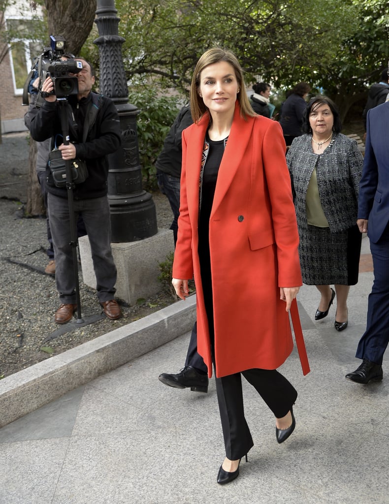 While visiting a children's hospital in February 2016, Queen Letizia paired her all-black outfit with two statement jackets — a sparkly cropped number with a fiery red Hugo Boss trench over the top.