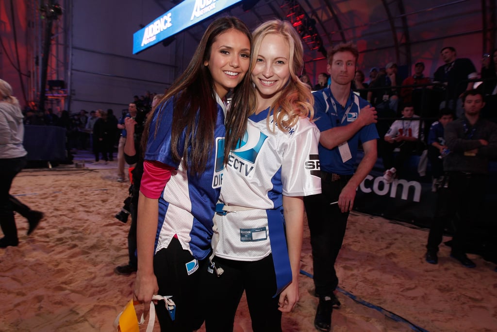 Nina Dobrev cuddled up to game opponent Candice Accola before the sixth annual Celebrity Beach Bowl Game in 2012.