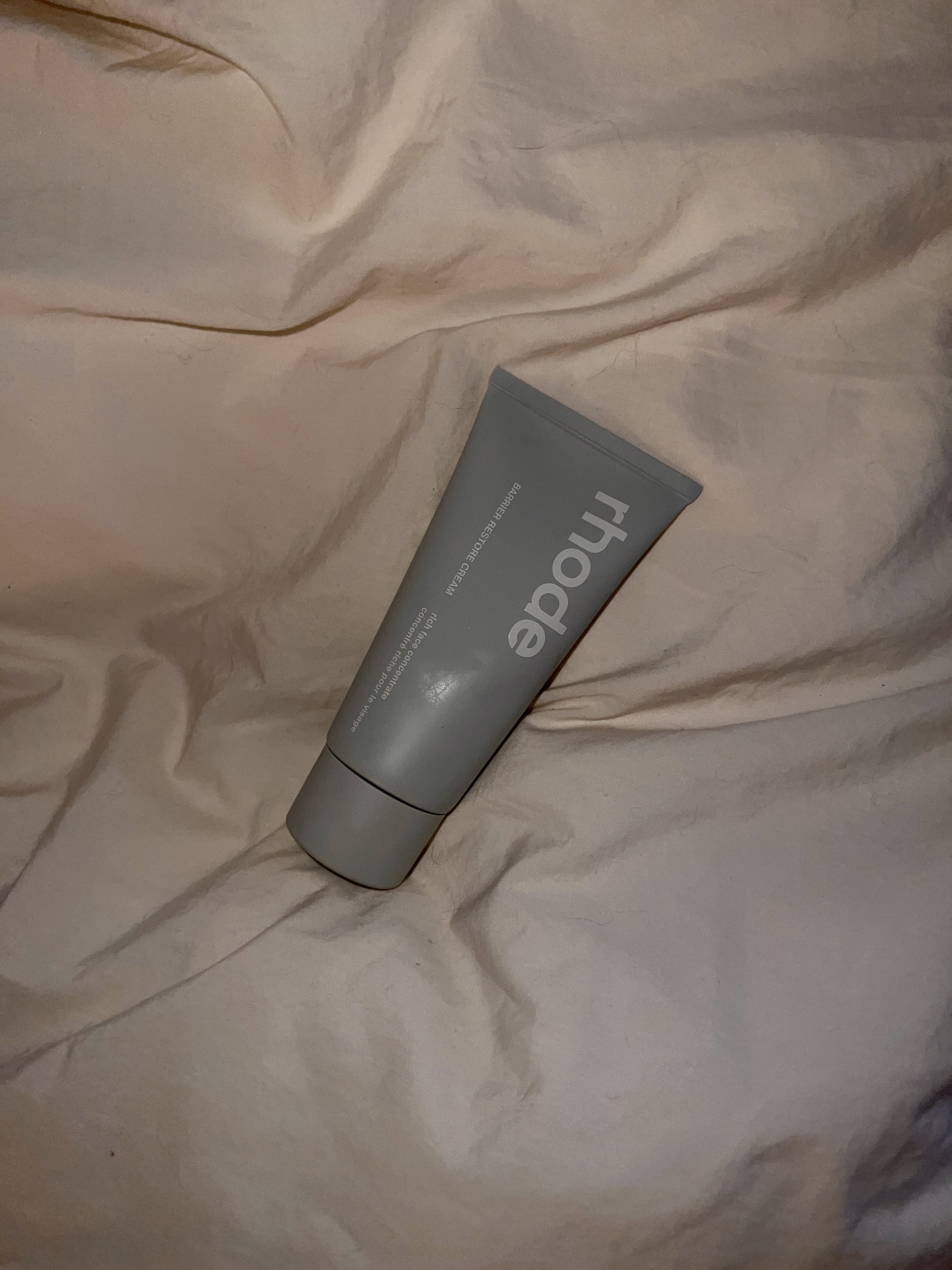 photo of the rhode barrier restore cream in a duvet cover
