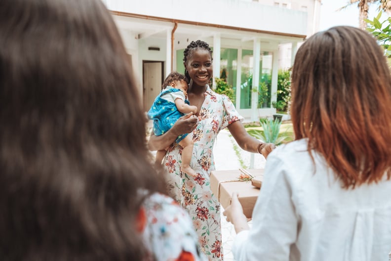 Group of three women celebrating newborn baby in a garden party.