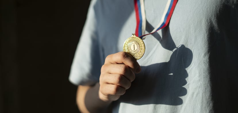 male sportsman with a golden medal on a chest, champion leader