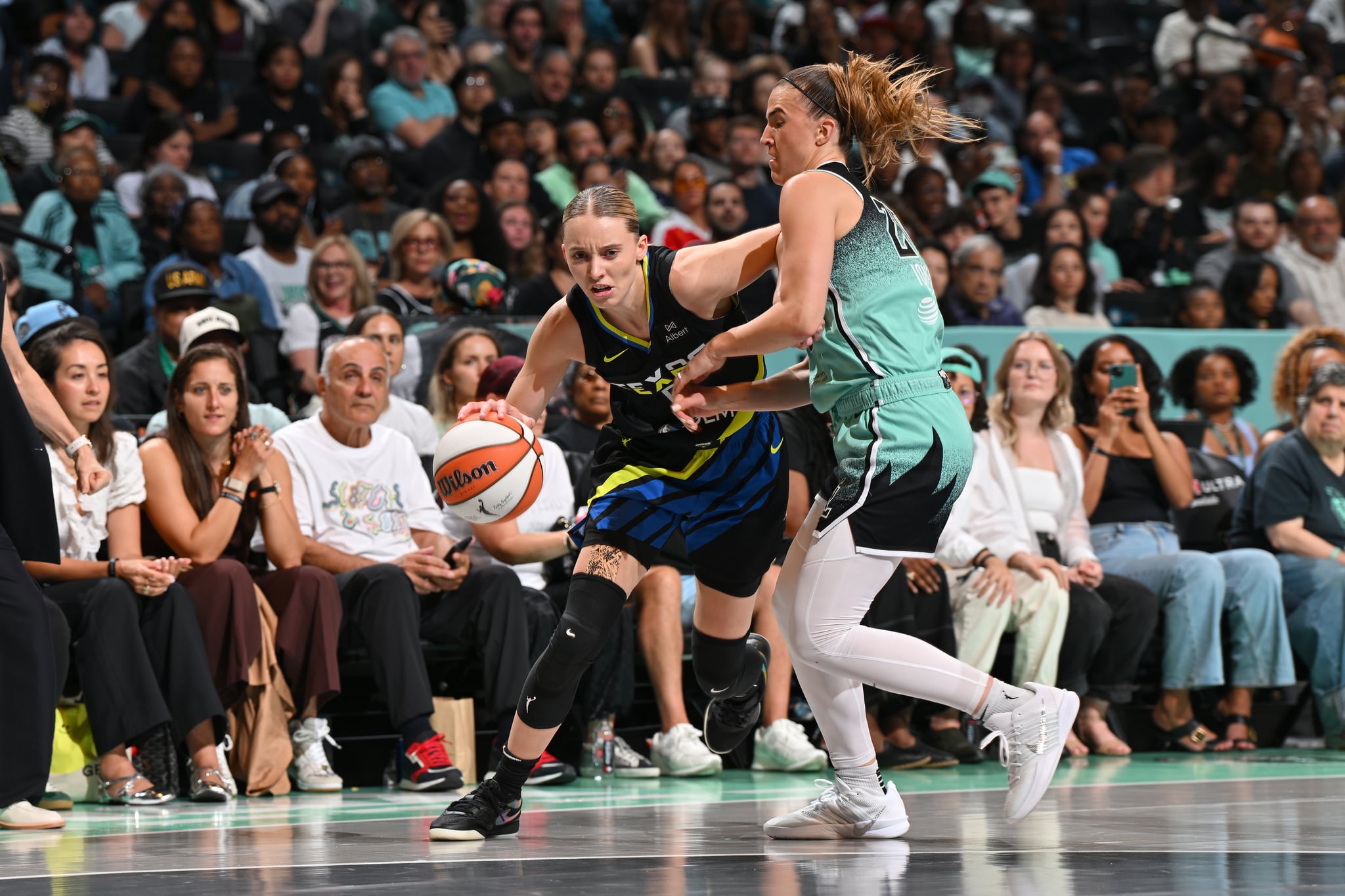 Paige Bueckers of the Dallas Wings drives to the basket as Sabrina Ionescu plays defense.