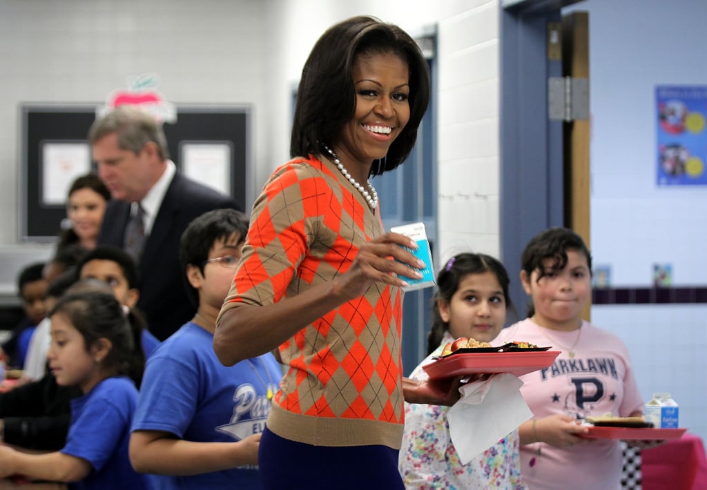 Michelle wore J.Crew's argyle jester sweater with pearls while working the cafeteria food line at an elementary school in Virginia in 2012.