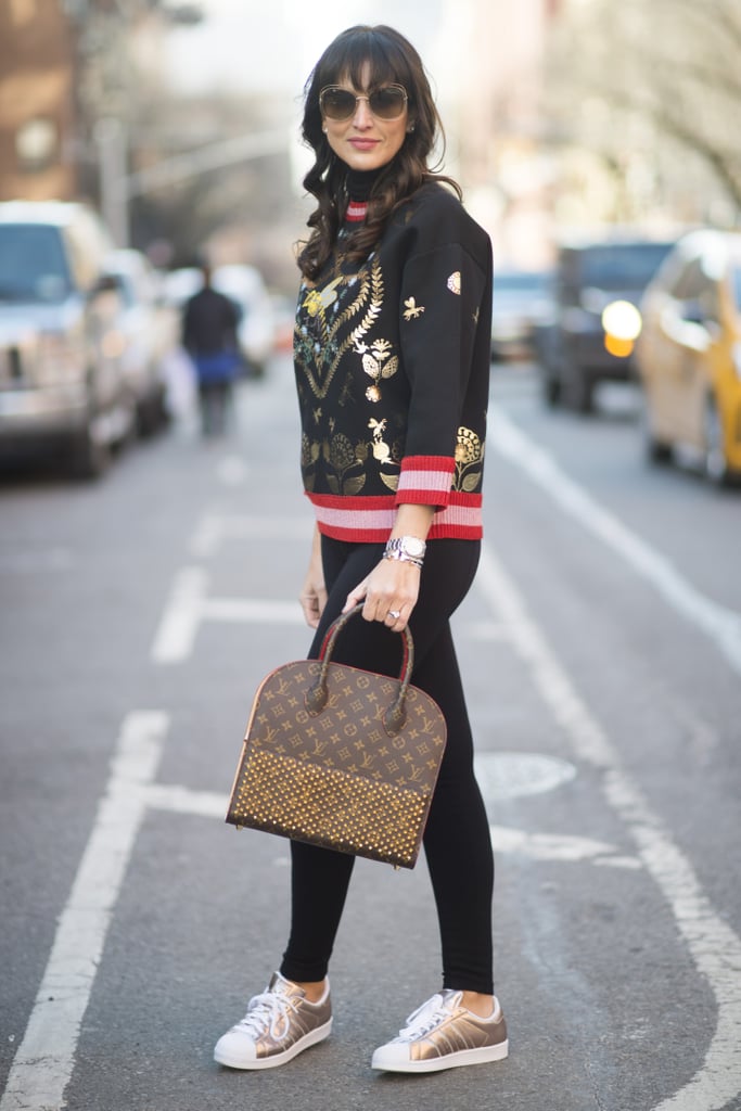 With an intricate sweater and metallic sneakers.