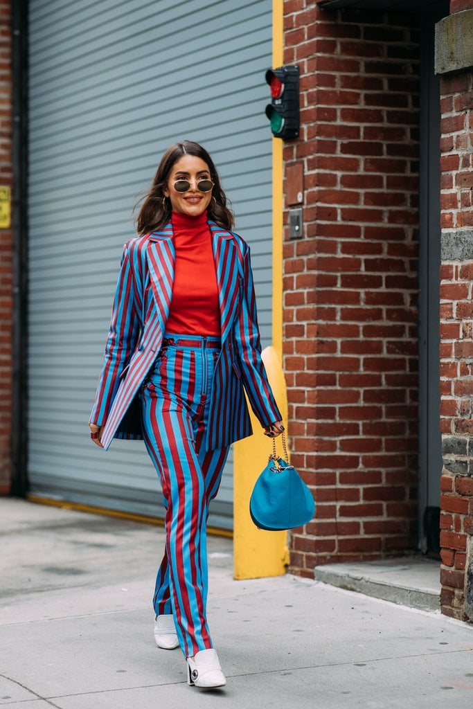 Camila Coelho's striped suit really pops off of her matching red shirt and blue bag.