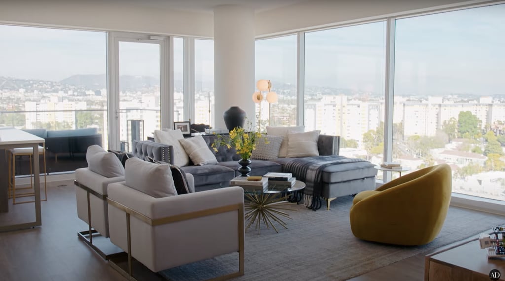 The living room is elegant and understated, featuring pops of yellow and gold.