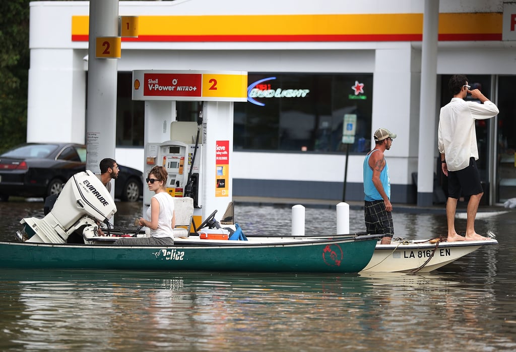 People get gas on boats while traversing a flooded neighborhood in Sorrento, LA.