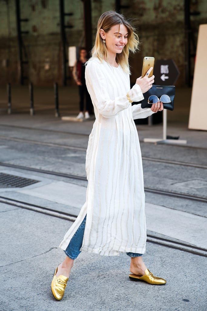 Ease into the dress and jeans combo by starting with a simple, neutral option. Natalie Cantell gave her look a pop of color with metallic gold mules.