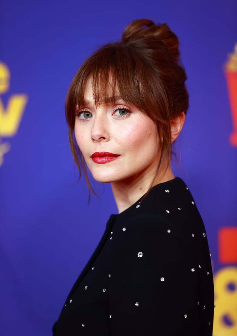 Elizabeth Olsen's Curtain Bangs and Top Knot Hairstyle and Bold Red Lip at the MTV Awards