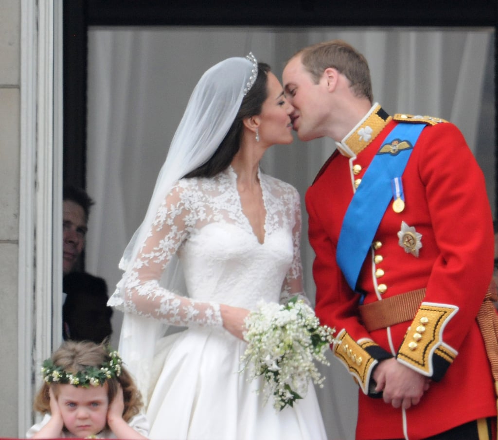 . . . but the 3-year-old was in a grumpier mood as the newlyweds had their first kiss on the balcony at Buckingham Palace.