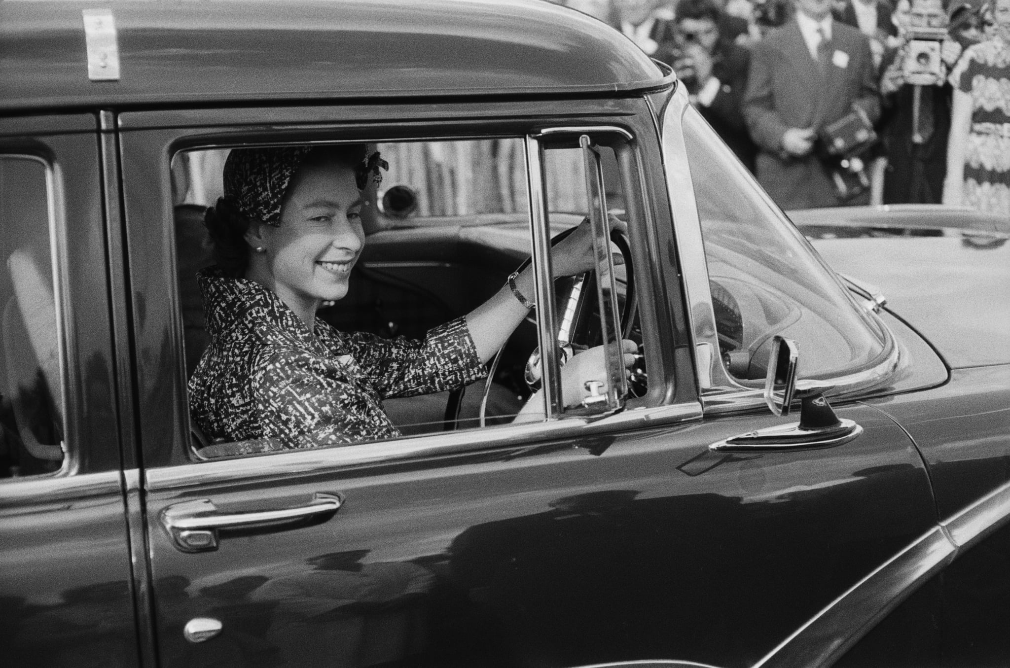 Queen Elizabeth II drives to a polo match in 1958