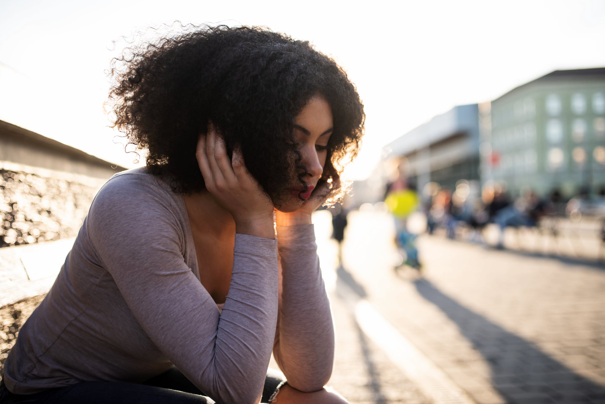Sad young teen black woman sitting alone