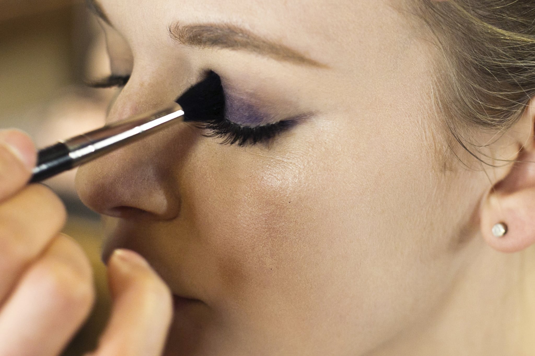 Line the upper lash line with the same deep violet liner. "I like to follow the contour of the eye shape instead making one straight line," Jennings says. Start with a thin line at the inner corner of the eye and create a gradually thicker line as it reaches the outer corner. 
Next, "stain" the lid with the pencil to aid in forming a long-lasting color base for the eye makeup. Then go over the pencil with a brush to blend out the color before it sets.