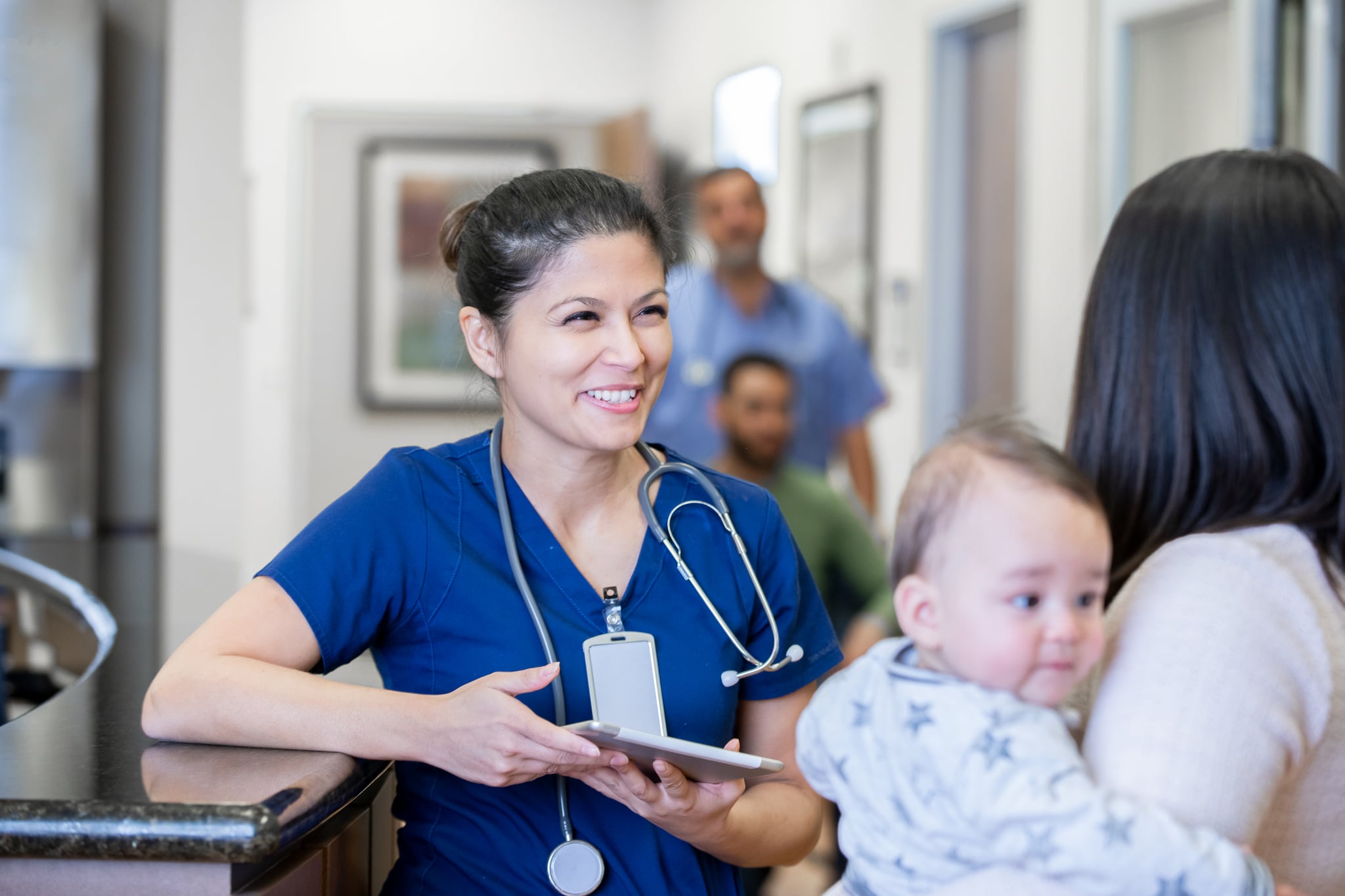 Nurse holding digital tablet in hospital hallway