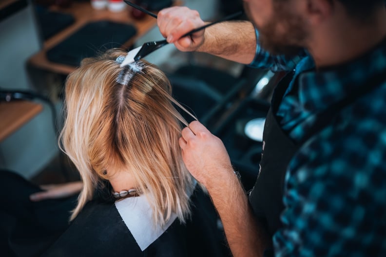 Close-up of a woman getting her hair dyed in a hair salon.