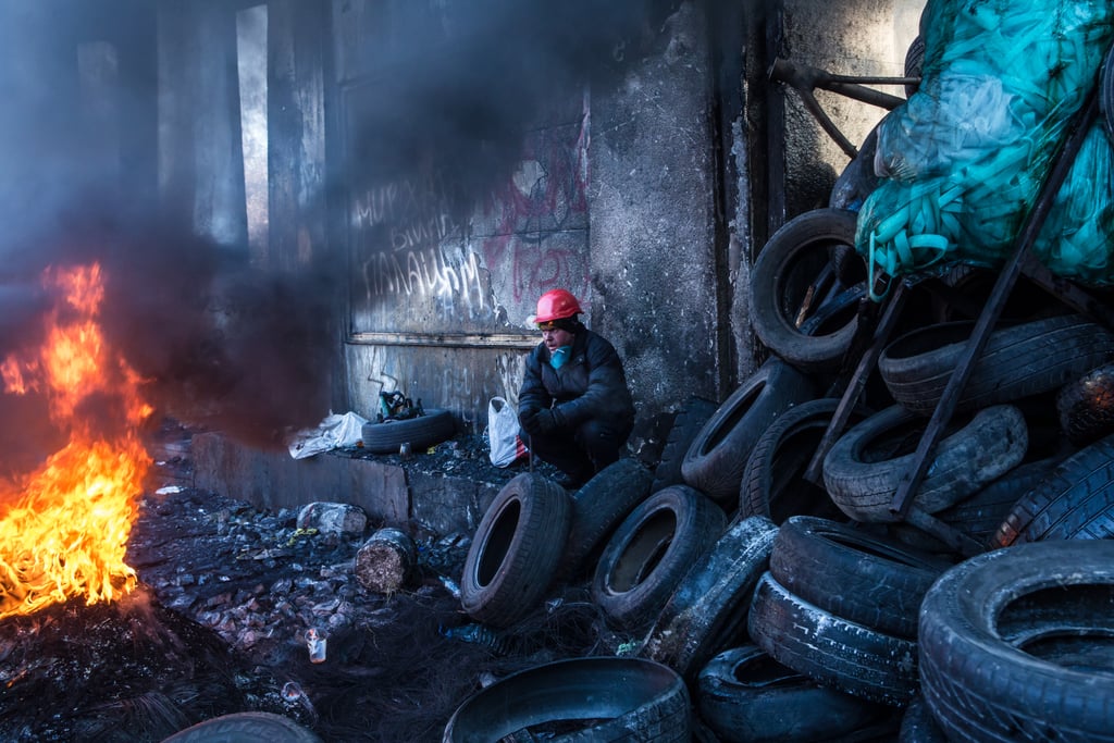 A protester wearing a gas mask stood among charred garbage as the group clashed with policemen.