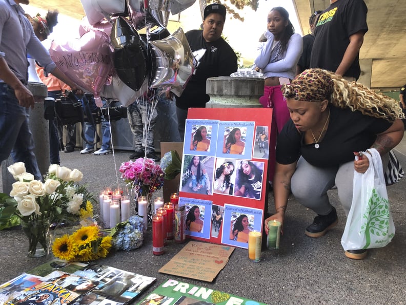 Malika Harris places a candle down for her sister Nia Wilson at a makeshift memorial outside the MacArthur Bay Area Rapid Transit station, Monday, July 23, 2018, in Oakland, Calif. A felon on parole fatally stabbed 18-year-old Nia Wilson in the neck and w